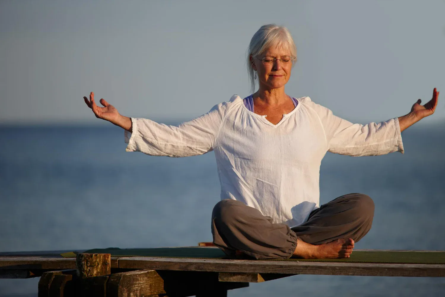 become calm like ocean full length shot attractive mature woman doing yoga pier out ocean